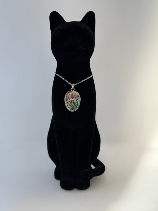 Black cat figurine wearing a necklace with a bear paw print pendant