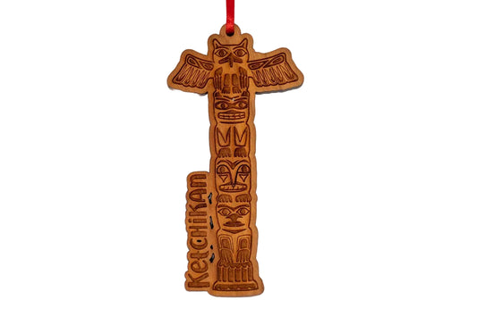 Wooden totem pole ornament with carvings and 'Ketchikan' text on a white background