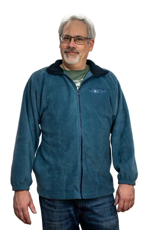 Man wearing a blue jacket with a Ketchikan Alaska logo against a white background