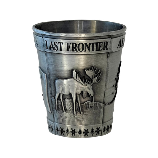 Metal shot glass with 'Last Frontier' text and moose design on a white background