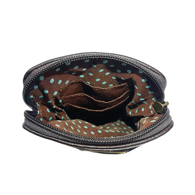 Close-up of an open crossbody bag with a zipper, showing the interior with a polka dot pattern.