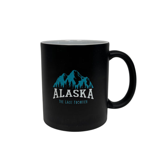 Black mug with blue mountain graphic and 'Alaska The Last Frontier' text