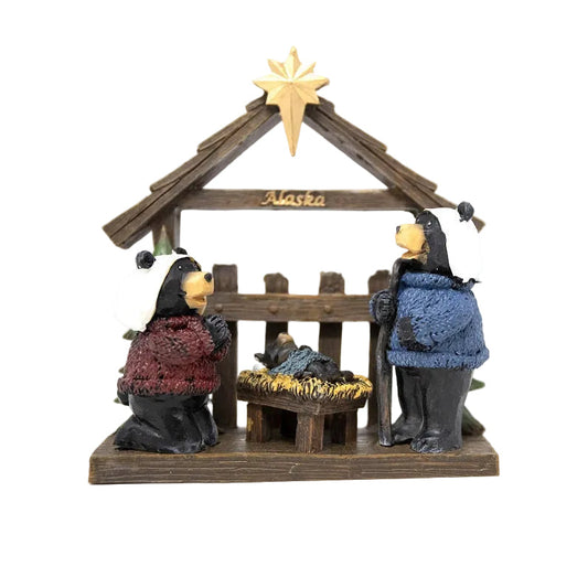 Wooden nativity scene with three figures and a stable, featuring a star on top, on a white background.