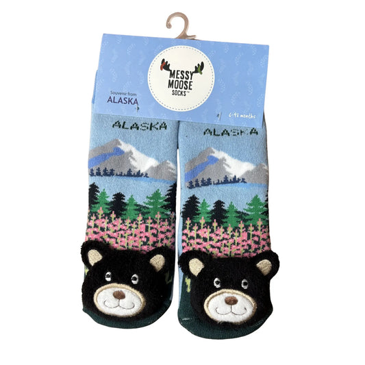 Pair of socks with bear design and 'Alaska' text, displayed in packaging with 'Messy Moose Socks' branding.