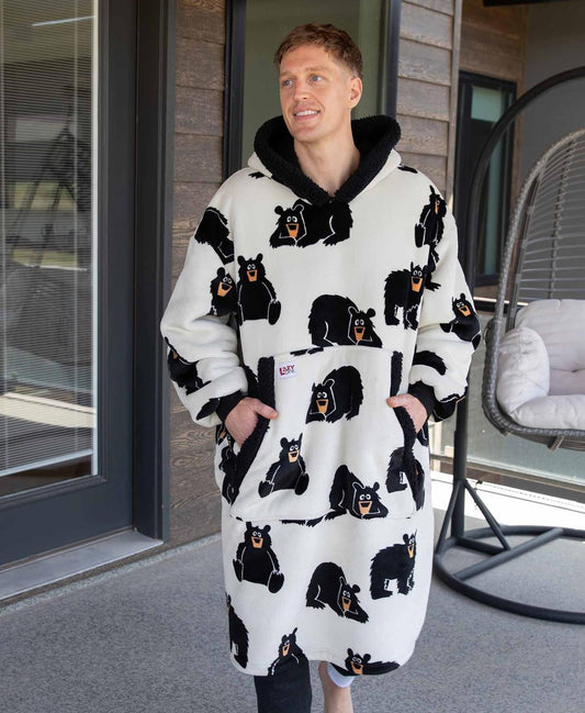 Person wearing a white robe with black bear patterns on a patio.