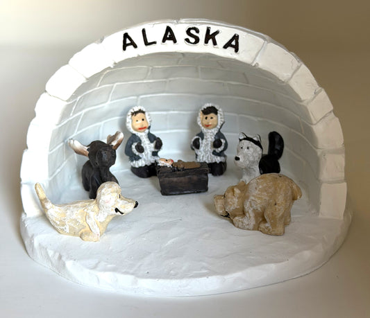 Nativity scene in an igloo with a seal, a moose, a wolf, and a bear. Alaska Text on top of igloo