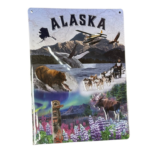 Tin sign featuring various Alaska-themed images including a bear, dogsledding, and mountains.