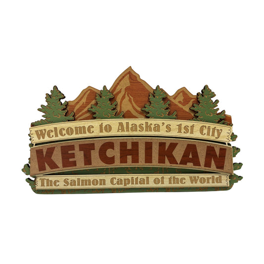 Decorative sign with mountain and tree design, featuring text about Ketchikan, Alaska.