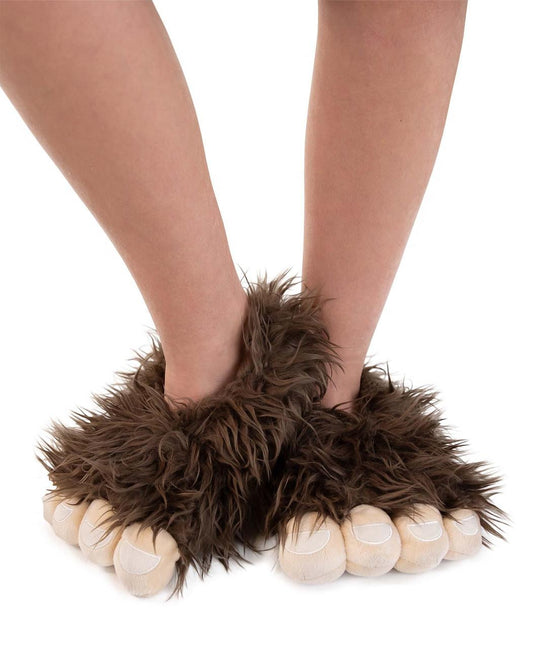 Brown sasquatch fuzzy slippers worn by a person on a white background