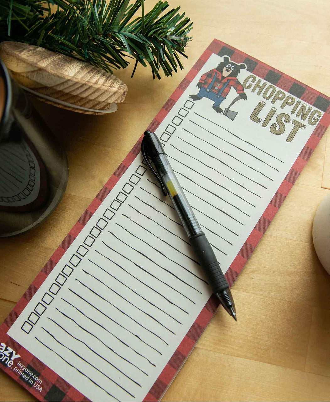 Notepad with 'Chopping List' design and pen on a wooden surface