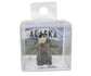 Small penguin figurine in a clear packaging with 'Alaska' background