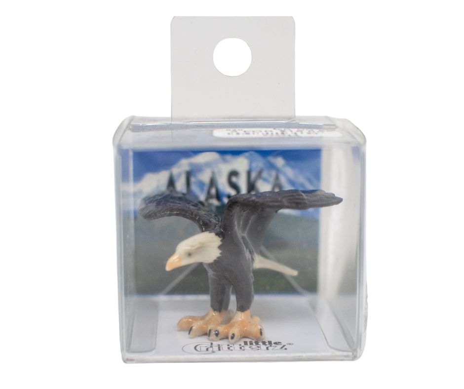 Eagle figurine in clear packaging with Alaska background