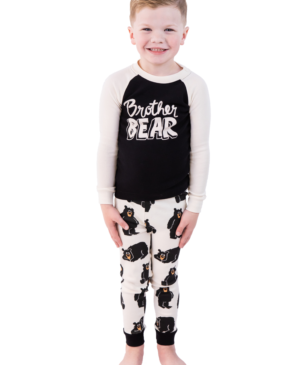 Child wearing a 'Brother Bear' pajama set with black and white design on a white background
