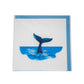 Card with a whale tail emerging from water on a white background