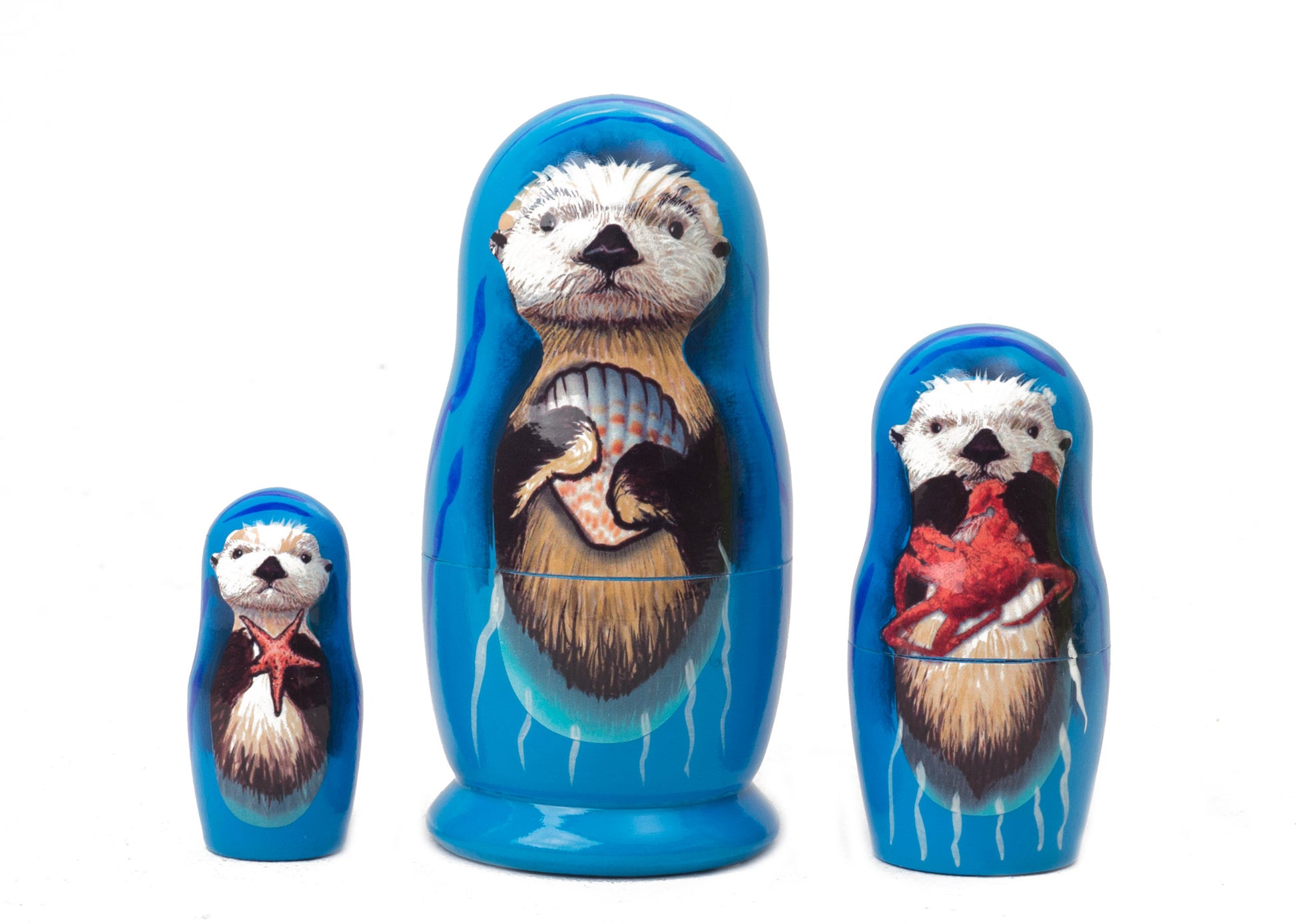 Set of three nesting dolls with otter designs on a white background
