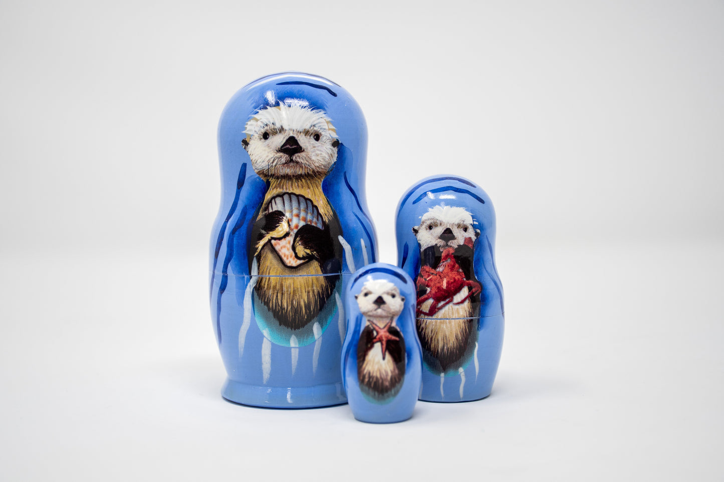 Set of nesting dolls with sea otter illustrations on a white background