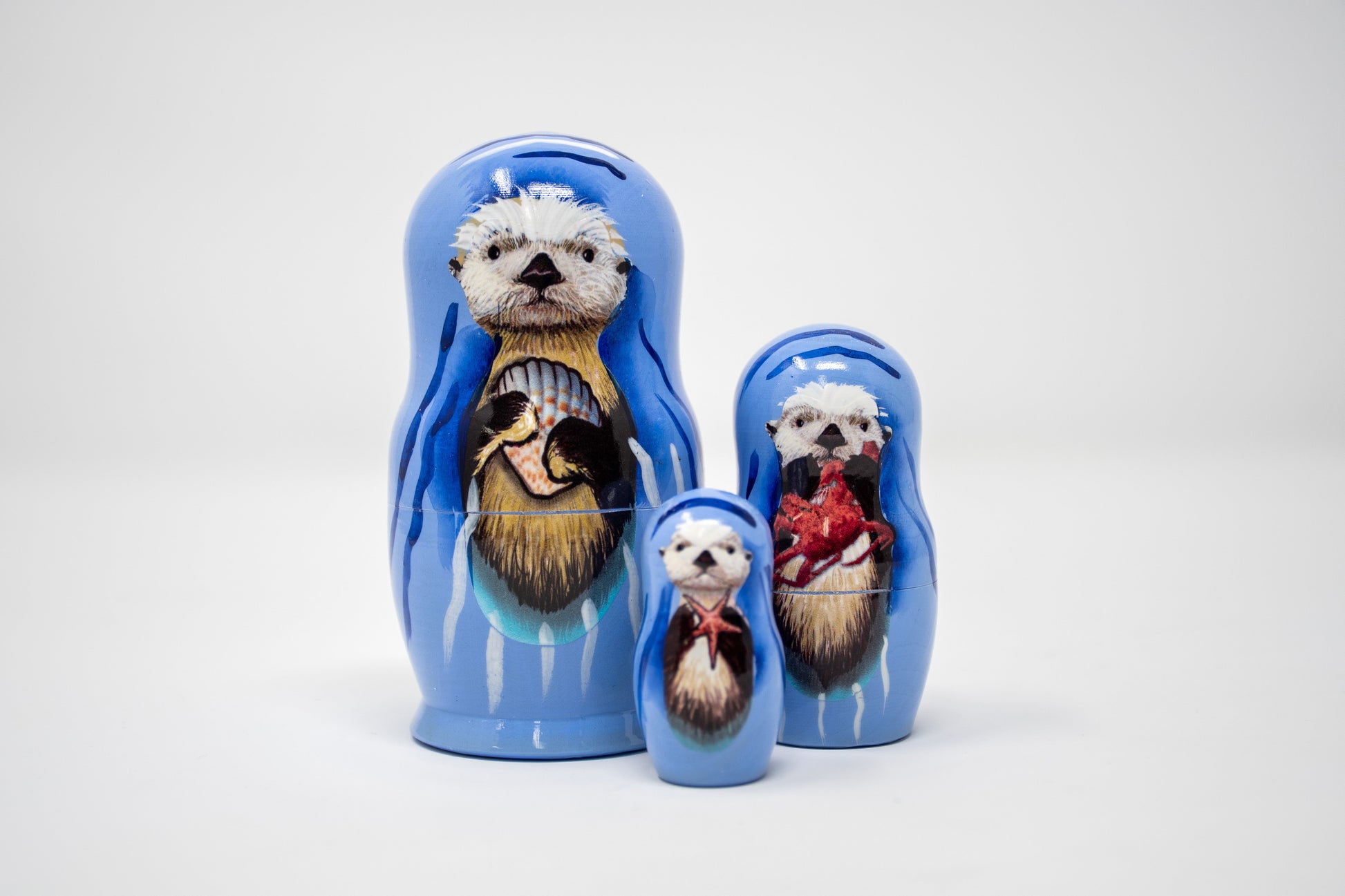 Set of nesting dolls with sea otter illustrations on a white background