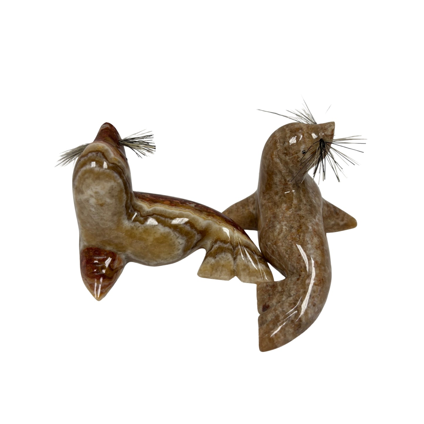 Two figurines of seals on a white background