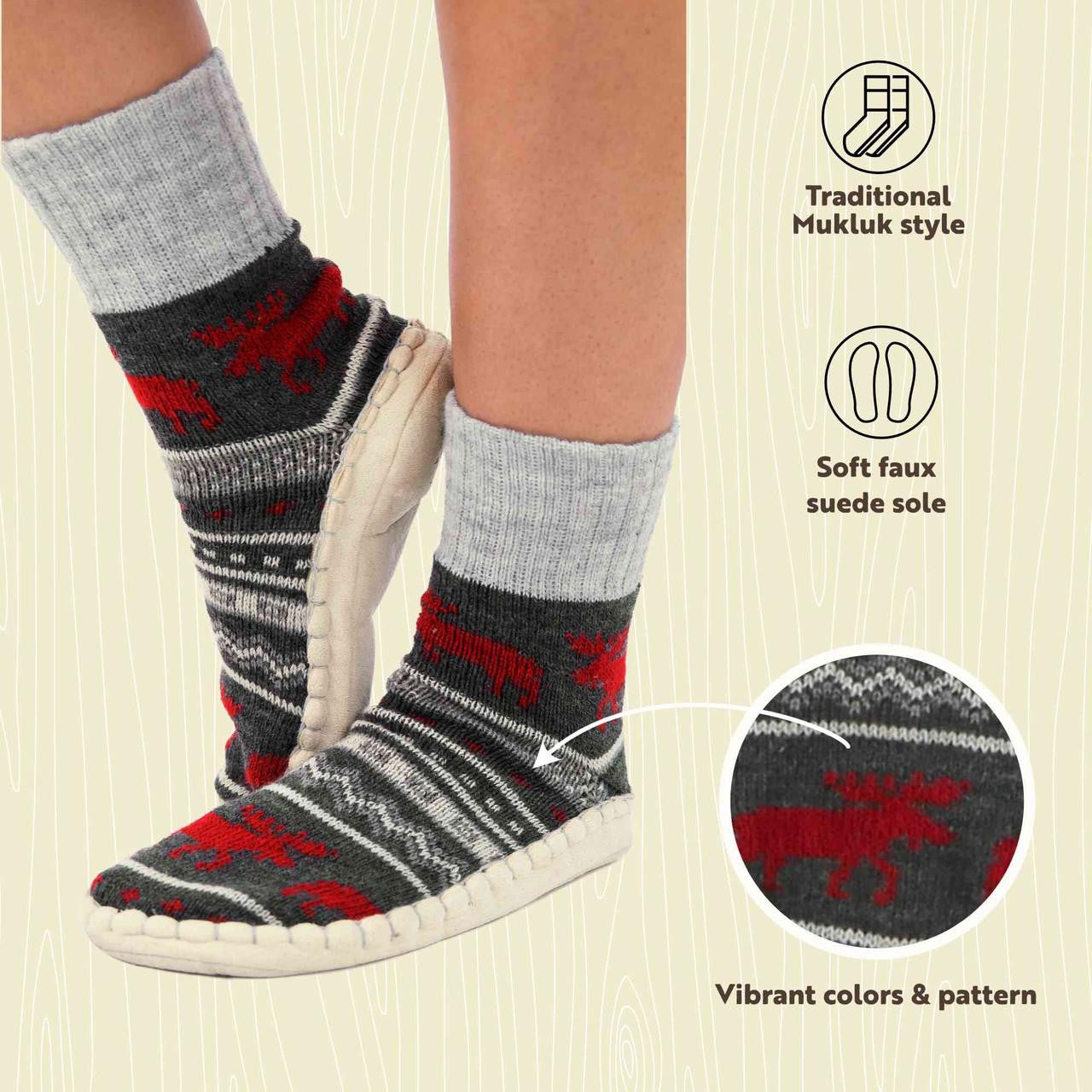 Gray mukluk with red moose pattern worn with white shoes on a beige background