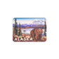 Fridge magnet with an illustration of a bear and mountains, featuring the word 'Alaska'.