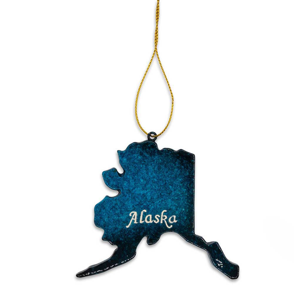 Blue Alaska-shaped ornament with 'Alaska' text on a white background