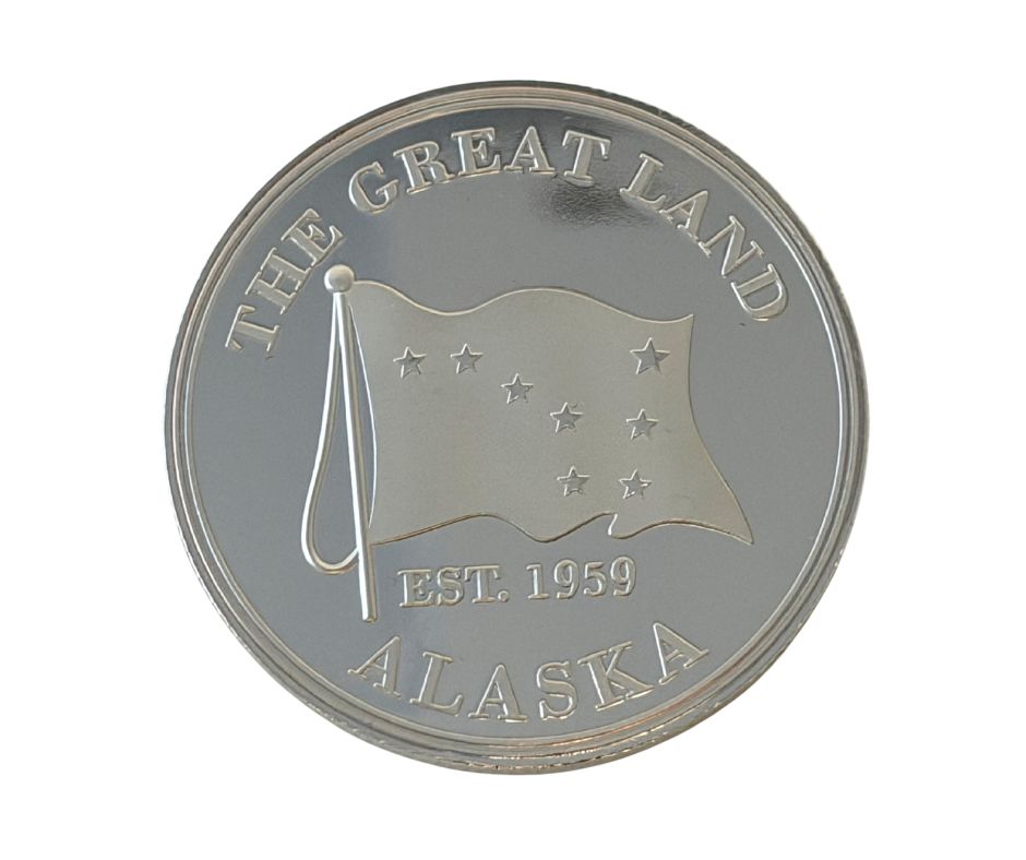 Silver coin with 'The Great Land Alaska' text and flag design 