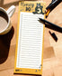Notepad with a bear illustration and 'Honey Do' text on a wooden surface with a mug and pen.