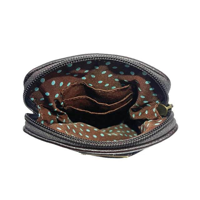 Close-up of an open crossbody bag with a zipper, showing the interior with a polka dot pattern.