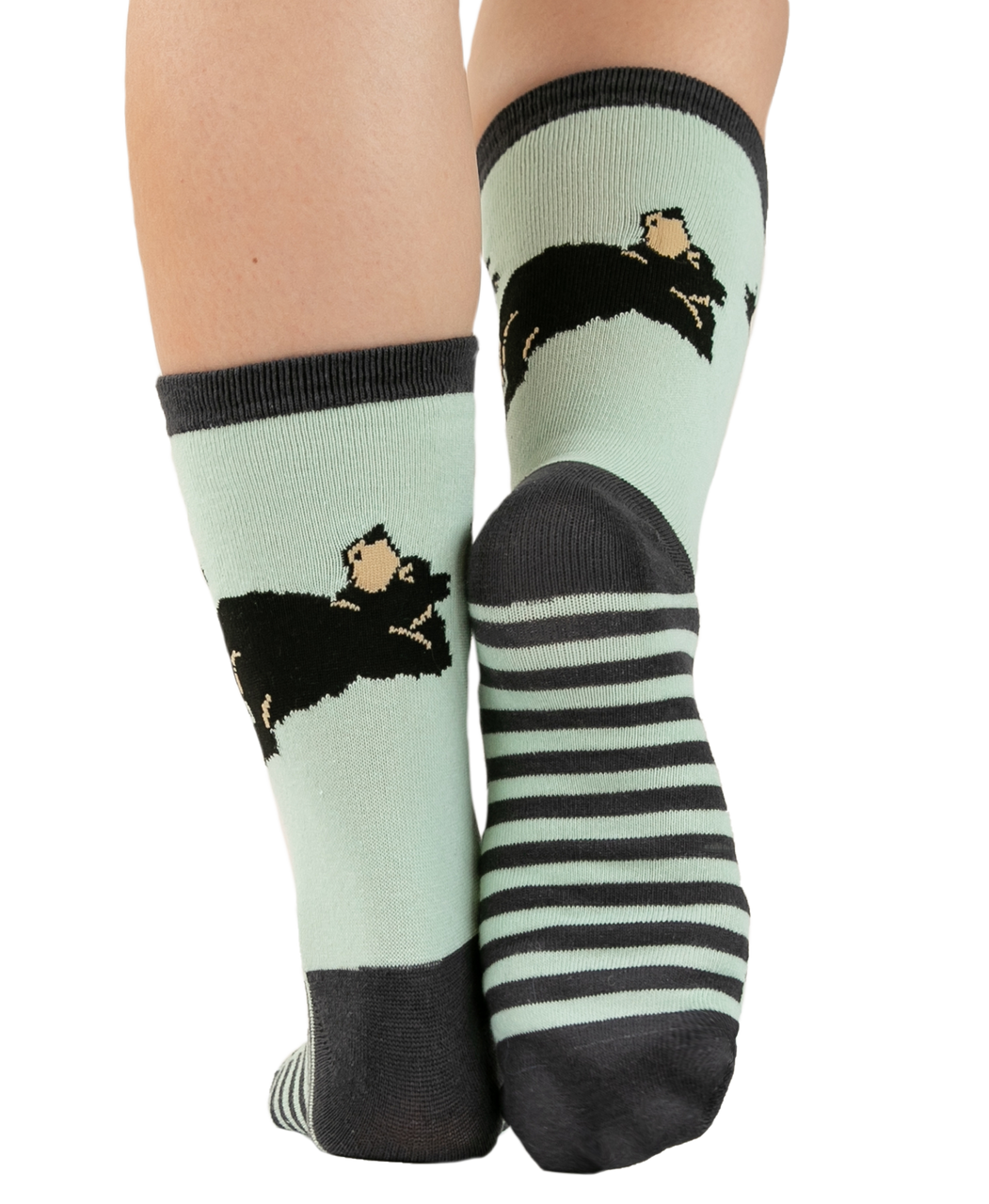 Pair of socks with black and white designs on a light green background