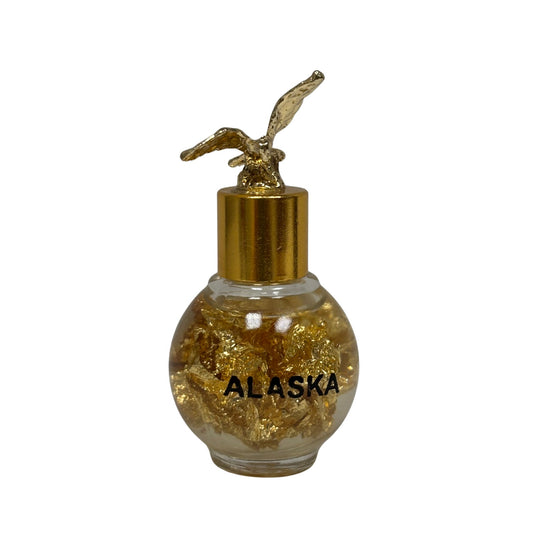 Bottle labeled 'Alaska' with gold flakes and a gold cap on a white background