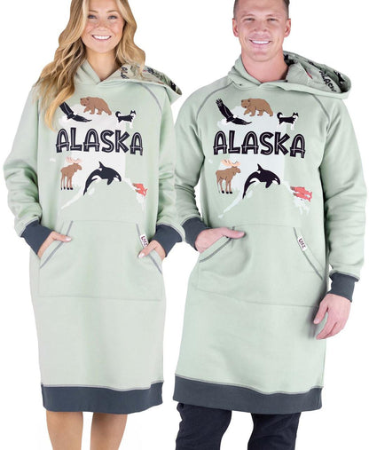 Two people wearing matching light green hoodies with 'Alaska' and nature-themed graphics on a white background.