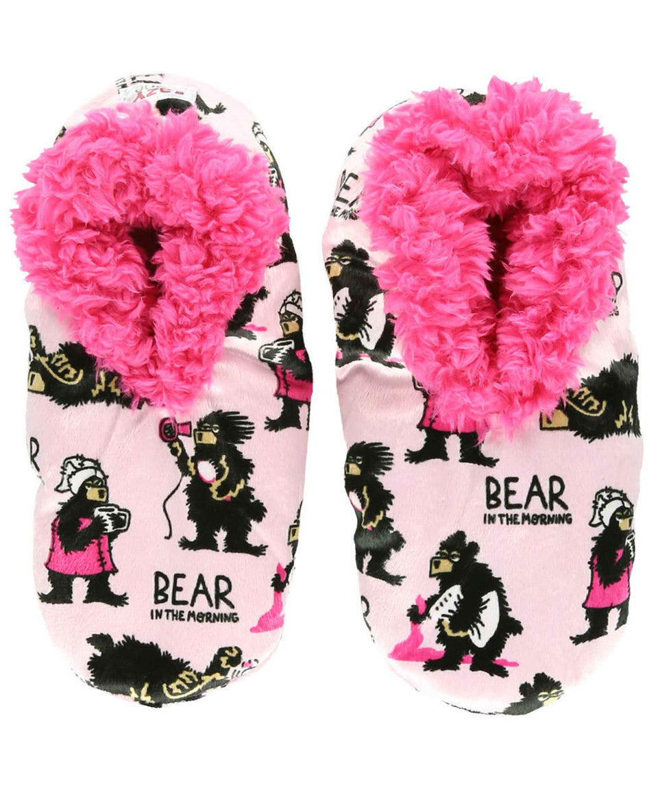 Pair of slippers with pink fuzzy interior and bear print on a white background