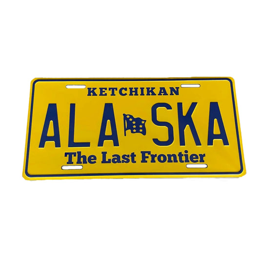 Yellow Alaska license plate with blue text and a flag symbol