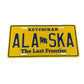 Yellow Alaska license plate with blue text and a flag symbol
