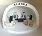 Nativity scene in an igloo with a seal, a moose, a wolf, and a bear. Alaska Text on top of igloo