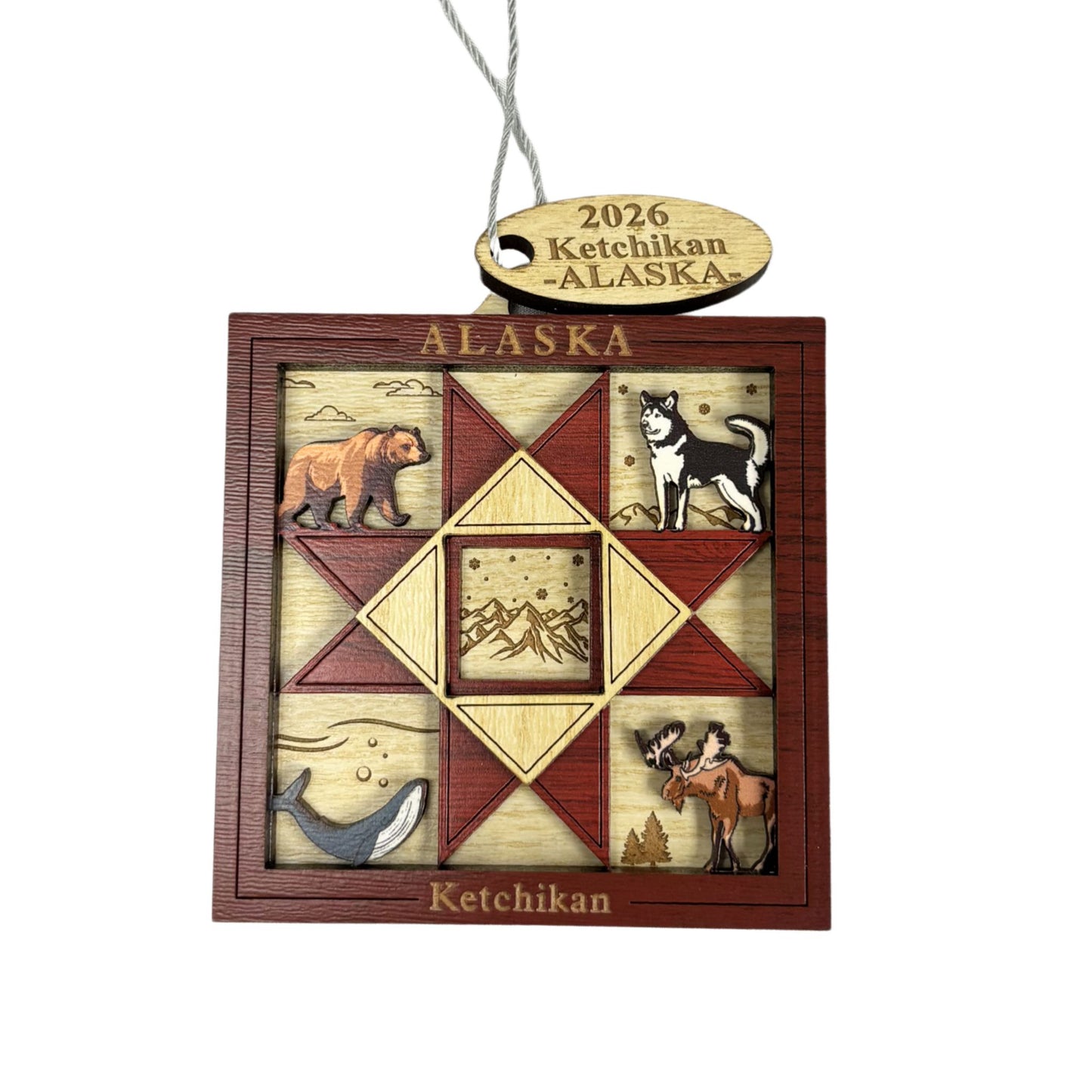Decorative Alaska ornament with animals and '2026 Ketchikan Alaska' text.