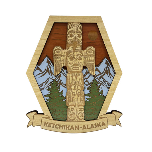 Wooden plaque with a totem pole design and mountains, featuring 'Ketchikan, Alaska' text.