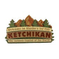 Decorative sign with mountain and tree design, featuring text about Ketchikan, Alaska.