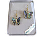 Butterfly-shaped earrings in a box with 'Wild Pearle' branding.