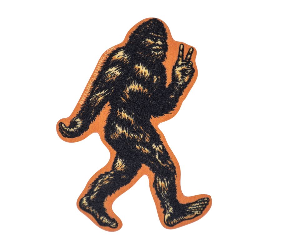 Sasquatch throwing up a peace sign sticker on an orange background