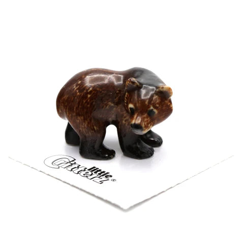 Small brown bear figurine on a white background