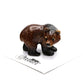 Small brown bear figurine on a white background