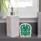 White soap dispenser with an Eco sponge with a green frog design on a bathroom counter