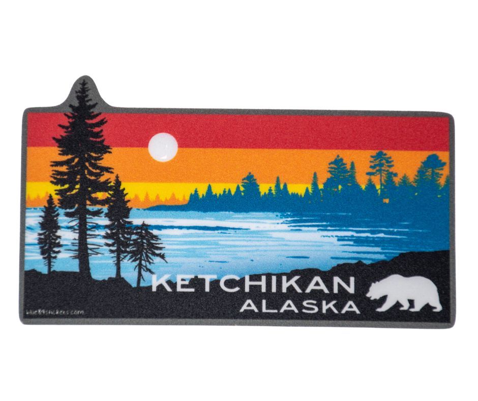 Silhouette of pine trees and a bear against a colorful sunset lake scene sticker