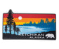 Silhouette of pine trees and a bear against a colorful sunset lake scene sticker